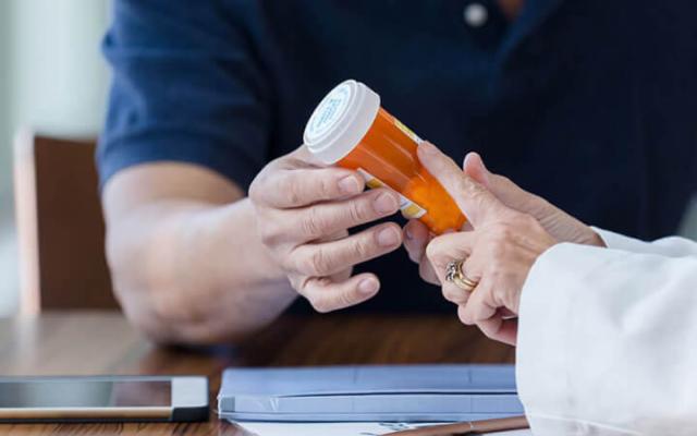 Person taking RX bottle